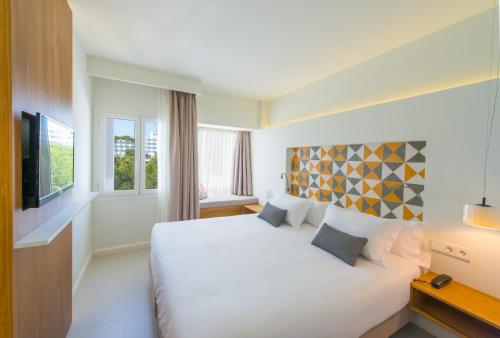 卡拉达沃Inturotel Esmeralda Villas的酒店客房设有白色的床和电视。