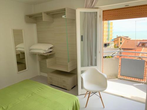 利多迪耶索罗Hotel & Residence Al Mare的卧室配有床、椅子和窗户。