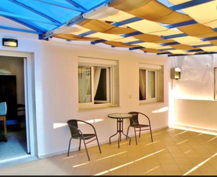斯卡拉伯塔麦斯Studios Elina的客房设有桌椅和蓝色天花板。