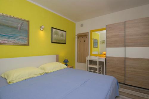 普莱曼图拉One bedroom apartment near the Kamenjak park in Prematura的一间卧室设有一张床和黄色的墙壁