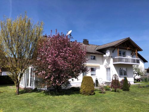 马克特奥伯多夫Christl's Ferienwohnung的院子里有一棵开花树的大白色房子