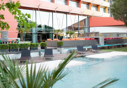 马德里美洲门酒店的大楼前设有游泳池和椅子的酒店