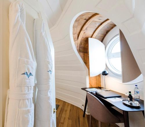 卡斯卡伊斯阿尔巴罗斯酒店的一间设有书桌、窗户和冲浪板的房间