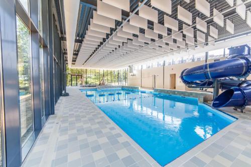 马斯特里赫特Dormio Hotel De Prins van Oranje的大楼内一个带滑梯的大型游泳池