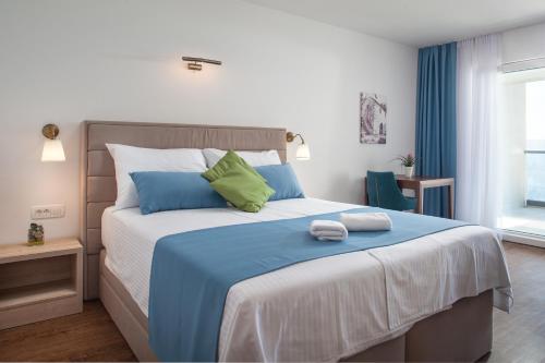 伯德古拉Villa Cascada的一间卧室配有一张带蓝色和绿色枕头的大床