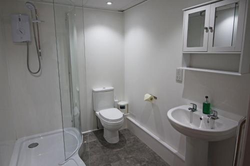 卡斯特Waves Guest Suites的浴室配有卫生间、盥洗盆和淋浴。