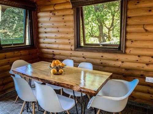 KhandriaVasiliou House Krimenos的一间带木桌和白色椅子的用餐室