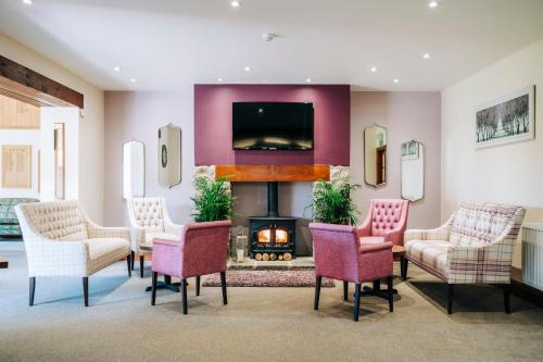 丘吉尔门迪普春天高尔夫乡村俱乐部乡村民宿的客厅设有壁炉、椅子和电视