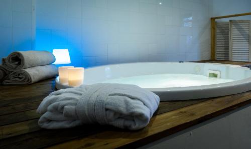 比斯卡罗斯海滩德拉普拉奇乐格兰德酒店的浴室配有带毛巾和蜡烛的浴缸。