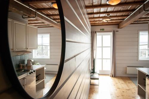 勒丁恩Lødingen Brygge的厨房拥有白色的墙壁和木地板,设有窗户。