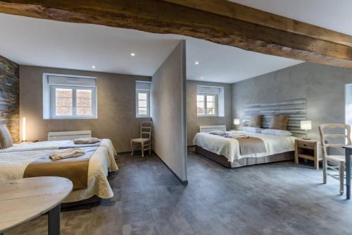 Balnot-sur-LaignesLes 3 cépages的一间卧室配有两张床和一张桌子及椅子