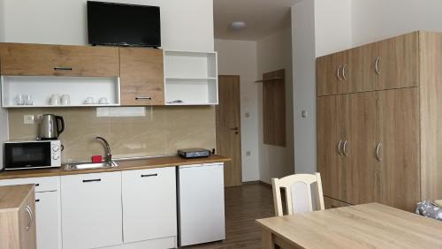VolkovceApartmánové ubytovanie VKF的小厨房配有白色橱柜和桌子