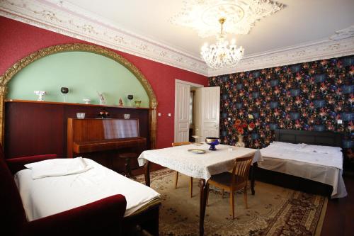 库塔伊西Nature House的客房设有两张床、一张桌子和一架钢琴。