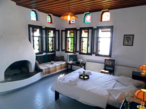 圣季米特里奥斯弗里奥尼斯酒店的大型客房设有一张床和一个壁炉。