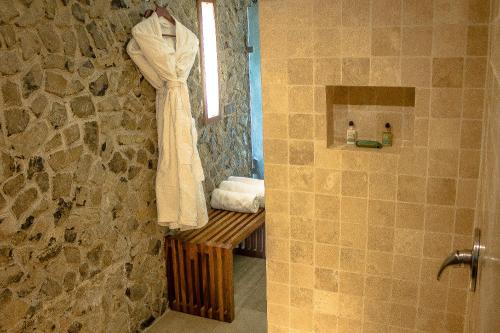 阿马蒂特兰卡维拉尔酒店的浴室的毛巾挂在石墙上