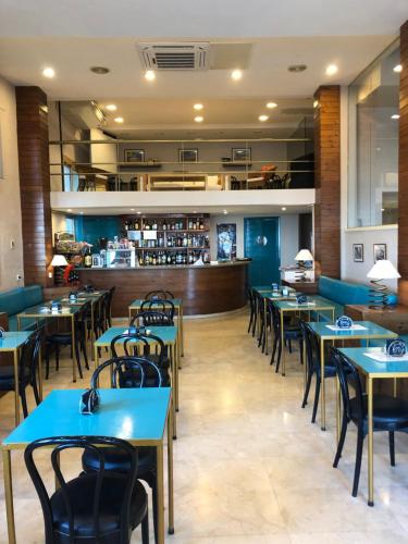 锡切斯塞利玛尔酒店的一间带桌椅的餐厅和一间酒吧