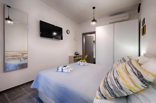 科米扎En Suite Room Demaria的卧室配有一张床,墙上配有电视。