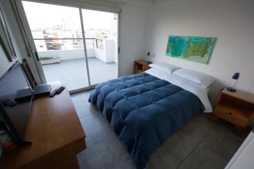 布宜诺斯艾利斯Ático Palermo的一间卧室配有一张带蓝色毯子的大床