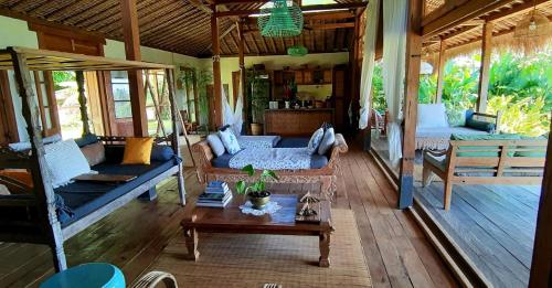 塞莱马德加Bali Beach Eco Villas Pondok Matekap的客厅配有沙发和桌子