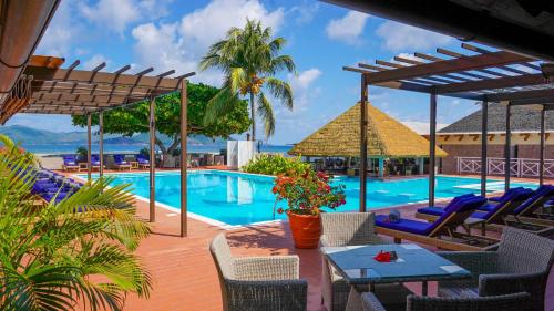 拉迪格岛拉迪格岛饭店的一个带椅子和桌子的度假村游泳池