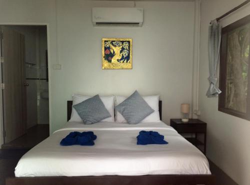 沙美岛日出海景度假村的一间卧室配有白色床和蓝色枕头
