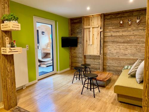 圣沃尔夫冈阿尔特格雷布勒雷精品公寓的客厅设有绿色的墙壁、沙发和凳子