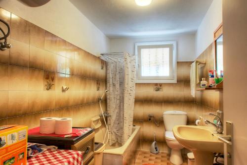 科孚镇KANAKADES VILLAGE HOUSE的一间带水槽和卫生间的浴室以及窗户。