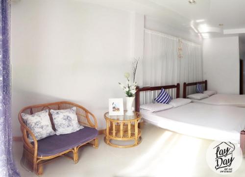 坤敬Lay Day的客房设有两张床、椅子和桌子。