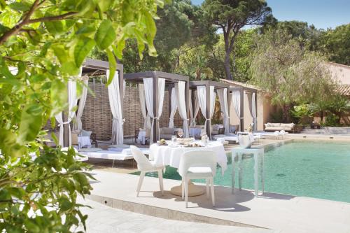 圣特罗佩MUSE Saint Tropez - Small Luxury Hotels of the World的游泳池旁带桌椅的用餐区