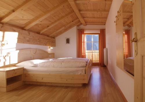 拉伊翁克尔车霍夫公寓的一间带一张床的卧室,位于带木制天花板的房间内