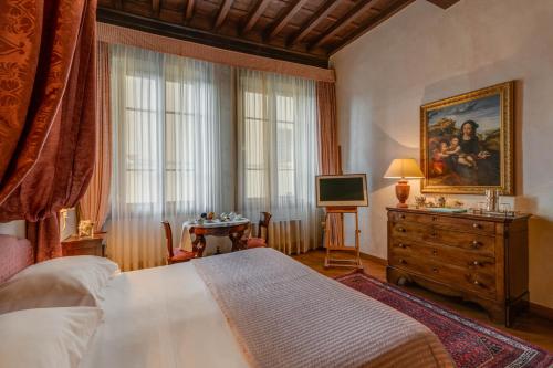 佛罗伦萨执政团广场德埃博卡居所酒店的一间卧室配有一张床、梳妆台和电视。
