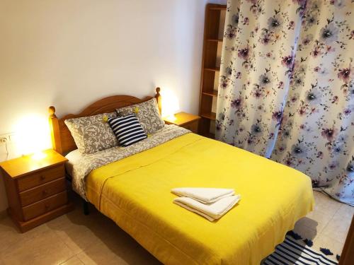 罗列特海岸Apartament Lloret de Mar with terrace的一间卧室配有黄色的床和毛巾