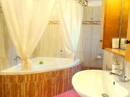帕拉代西翁Cozy apartment in Paradisi的带浴缸和盥洗盆的浴室