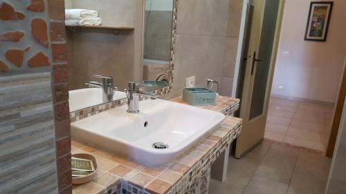 皮昂比诺Casa vicino al mare的浴室设有白色水槽和镜子