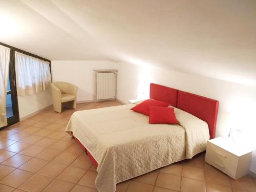 蒙多维Cascina Bringin的一间卧室配有一张红色床头板的床