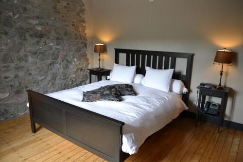 迪南Auberge de Bouvignes的卧室配有一张带白色床单和枕头的大床。
