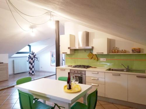 蒙多维Cascina Bringin的厨房配有白色的桌子和绿色的椅子