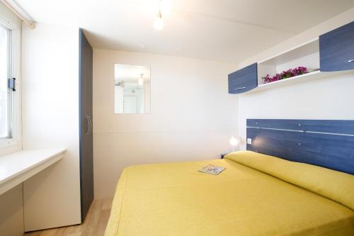 维耶斯泰拜亚迪坎比酒店的一间卧室设有黄色的床和窗户。