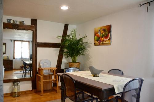 希尔蒂盖姆Au Merlenchanteur的一间带桌椅和植物的用餐室