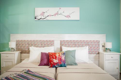 卡拉马孔Villa Sophie - Sunny Retreat!的一间卧室配有两张带色彩缤纷枕头的床