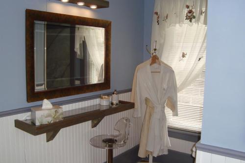 梅戈格博伊斯住宿加早餐酒店的浴室设有镜子和椅子上的浴袍