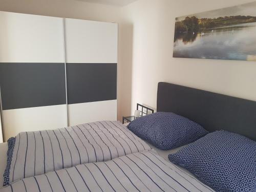 埃德湖Ferienwohnung Berges的一间卧室配有床和2个蓝色枕头