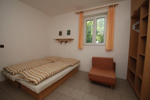 捷克布杰约维采Na Černém potoce的卧室配有床、椅子和窗户。