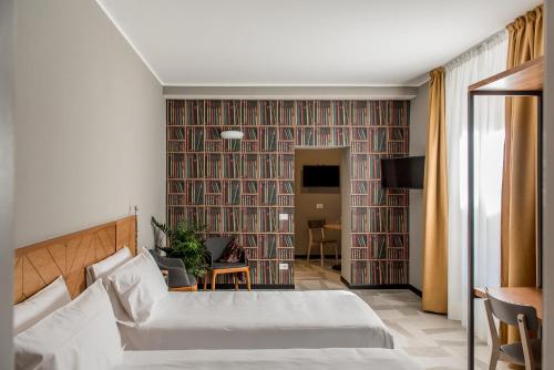 米兰APARTHOTEL CASA MIA的酒店客房设有一张床和一堵大墙书