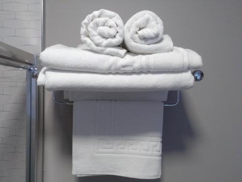 萨里亚Travesia Rooms的浴室内架上的毛巾堆