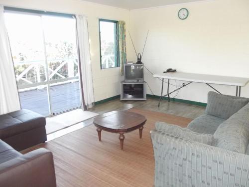 努库阿洛法绿色度假屋山林小屋的带沙发、桌子和电视的客厅
