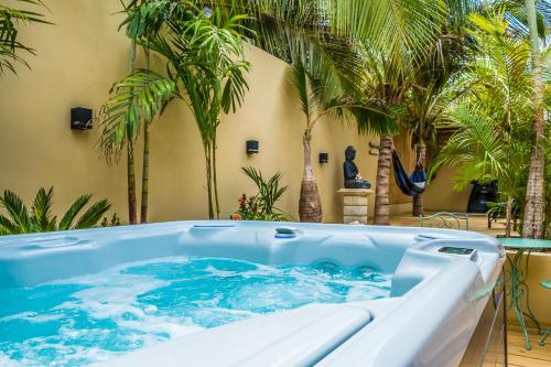 克拉伦代克Bamboo Bonaire Boutique Resort的棕榈树庭院内的热水浴池