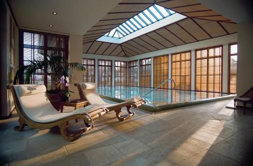 韦斯特兰汉堡城市酒店的大型客房设有游泳池和2把椅子