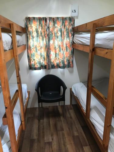 Meningie艾伯特湖大篷车公园酒店的带两张双层床和椅子的房间