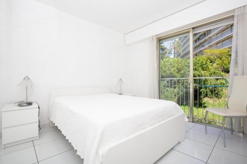 戛纳Appartement vacances cannes的白色的卧室设有白色的床和窗户。
